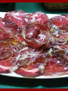 Una foto de Cecina con virutas de queso manchego