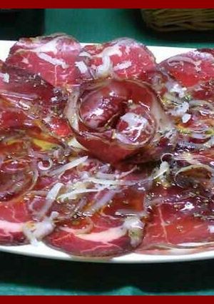 Una foto de Cecina con virutas de queso manchego