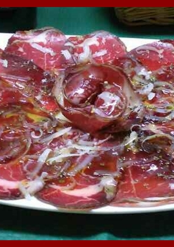 Una foto de Cecina con virutas de queso manchego