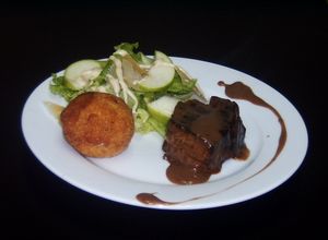 Una foto de Filet Mignon, aranccinis de queso y ensalada rústica