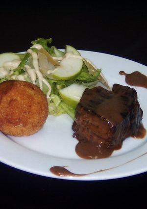 Una foto de Filet Mignon, aranccinis de queso y ensalada rústica