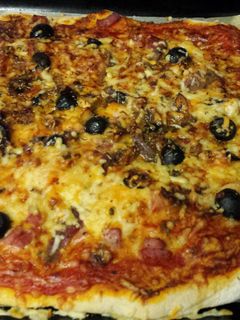 Una foto de Pizza casera de jamón, queso y anchoas