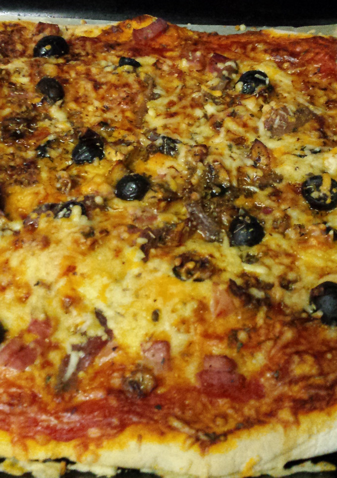 Una foto de Pizza casera de jamón, queso y anchoas