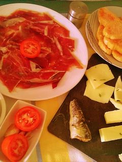Una foto de Pan con tomate, jamón ibérico y quesos surtidos