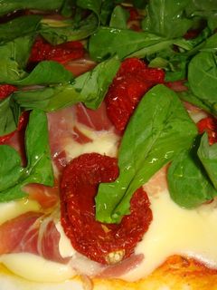 Una foto de Pizza de jamón crudo, tomatitos secos y rúcula