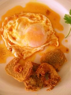 Una foto de Huevo frito con pimentón dulce y filetes de alcachofa rebozada