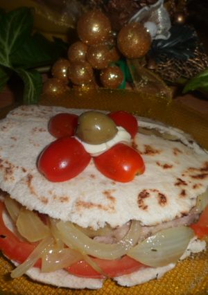 Una foto de Pan árabe con carne y cebollas