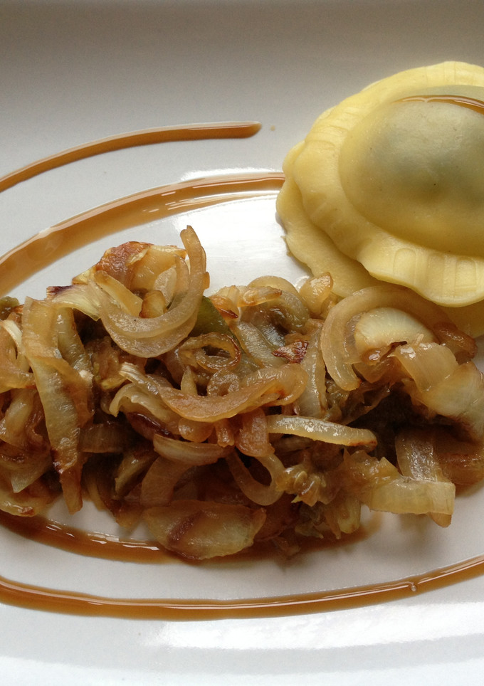 Una foto de Raviolis rellenos de espinacas acompañados de cebolla y mermelada de pimientos verdes
