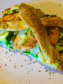 Una foto de Trenza de pizza con brócoli, calabacín y salmón