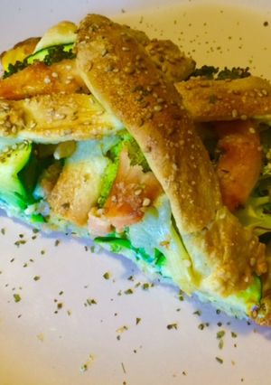 Una foto de Trenza de pizza con brócoli, calabacín y salmón