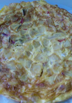 Una foto de Tortilla de patatas con cebolla y pimientos