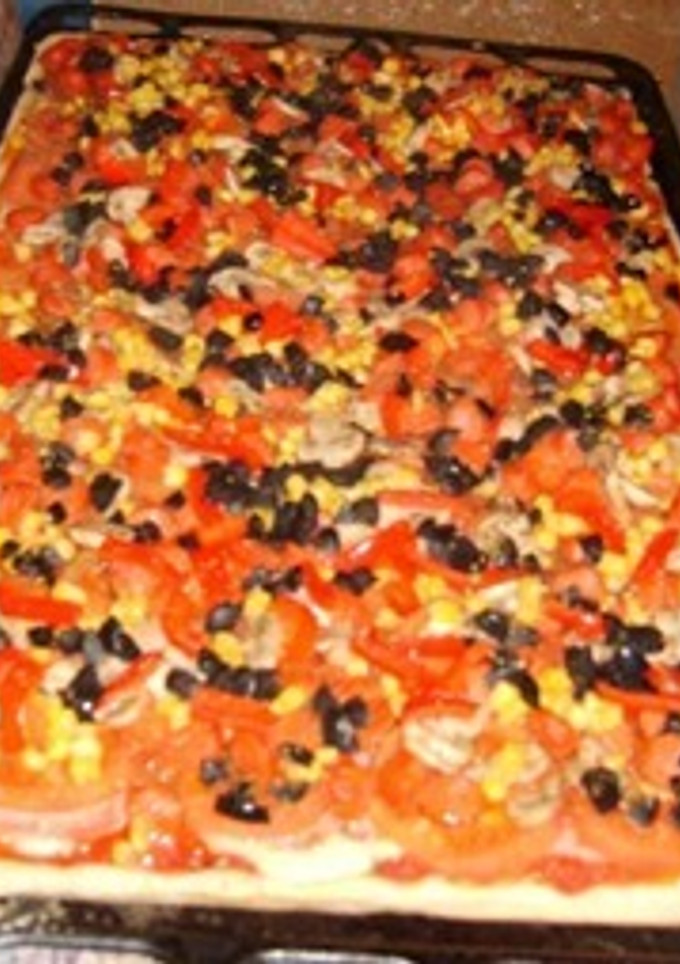 Una foto de Pizza casera con muchos ingredientes