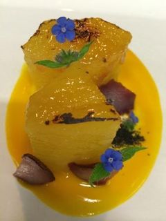 Una foto de Piña caramelizada con aroma de azafrán y coulis de mango