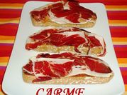 Una foto de tostadas con jamón serrano