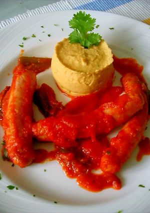 Una foto de Salchichas con tomate y puré de garbanzos