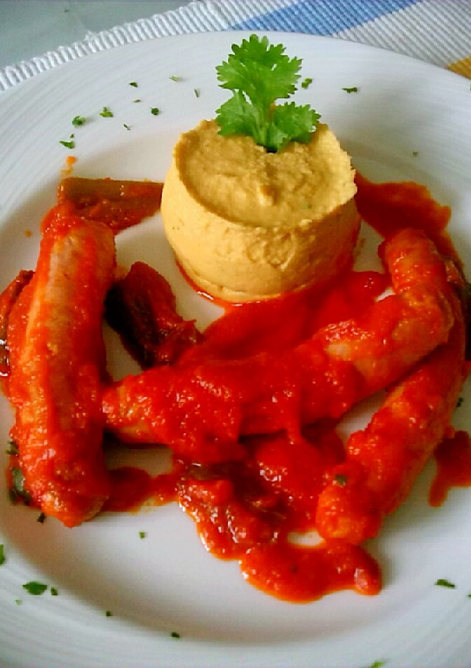 Una foto de Salchichas con tomate y puré de garbanzos