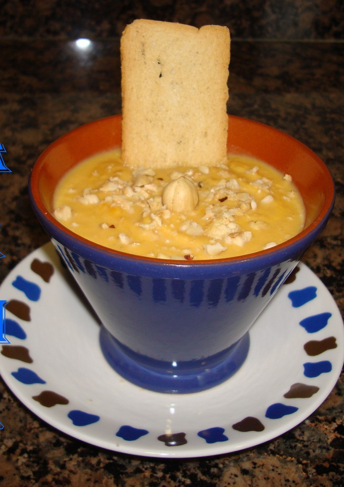 Una foto de Crema de esparragos, zanahoria, jamón y avellanas