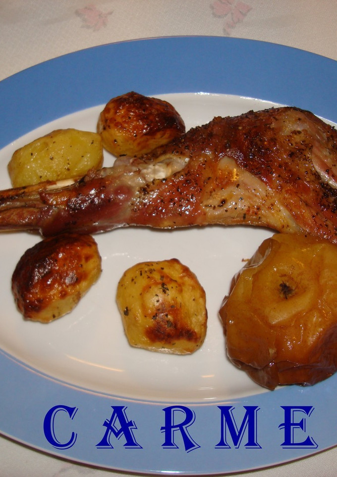 Una foto de Cabrito asado al horno, con patatitas y manzanas