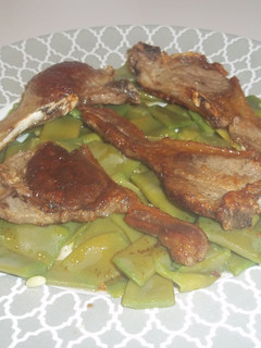 Una foto de Chuletas de cordero sobre manto de judías verdes