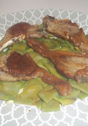 Una foto de Chuletas de cordero sobre manto de judías verdes