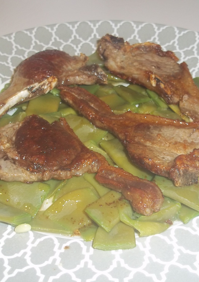 Una foto de Chuletas de cordero sobre manto de judías verdes
