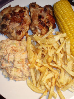 Una foto de Pollo frito con puré de papas, ensalada de col y mazorcas de maíz