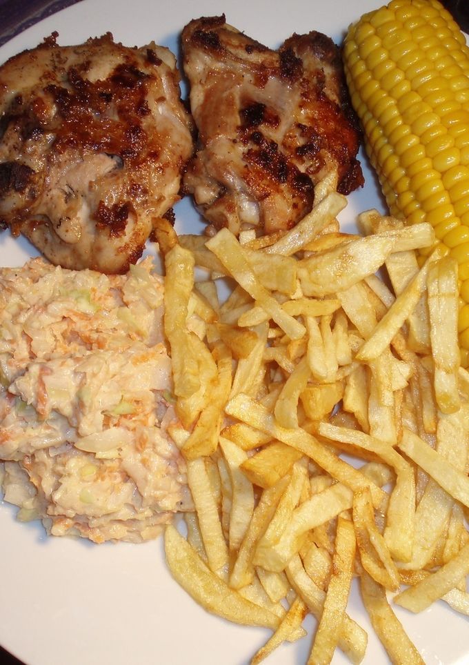 Una foto de Pollo frito con puré de papas, ensalada de col y mazorcas de maíz