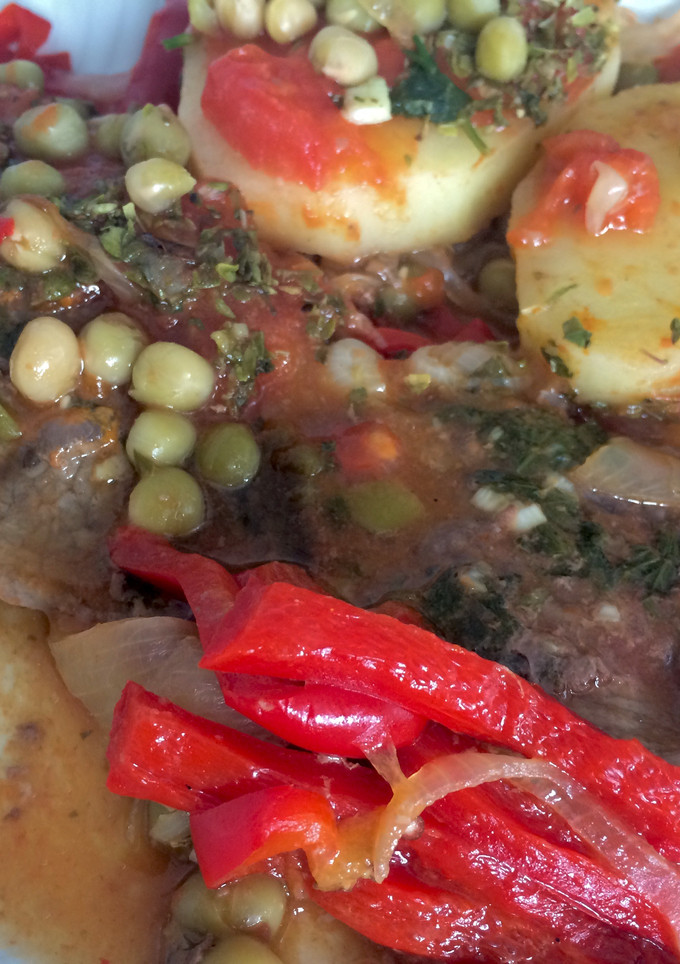 Una foto de Bifes a la criolla con papas y arvejas