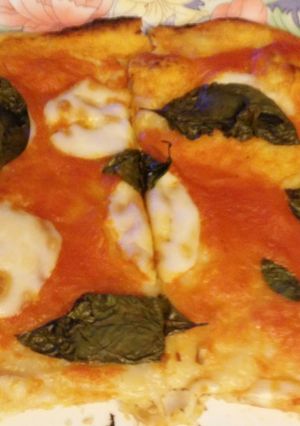 Una foto de Pizza casera de tomate, albahaca y mozzarela