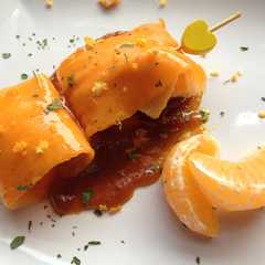 Una foto de Carpaccio de calabaza relleno de pechuga de pollo acompañado de reducción de soja y mandarina