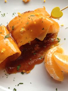 Una foto de Carpaccio de calabaza relleno de pechuga de pollo acompañado de reducción de soja y mandarina