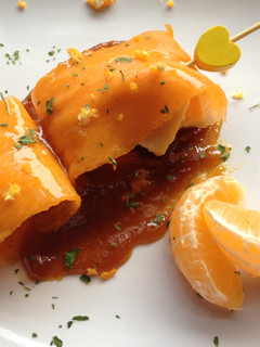 Una foto de Carpaccio de calabaza relleno de pechuga de pollo acompañado de reducción de soja y mandarina