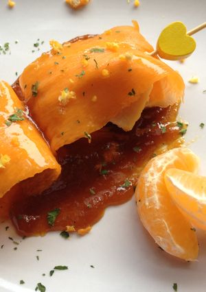 Una foto de Carpaccio de calabaza relleno de pechuga de pollo acompañado de reducción de soja y mandarina