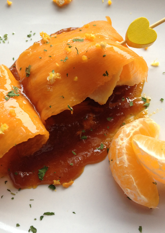 Una foto de Carpaccio de calabaza relleno de pechuga de pollo acompañado de reducción de soja y mandarina