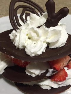 Una foto de Milhojas de chocolate con fresas y crema chantilly