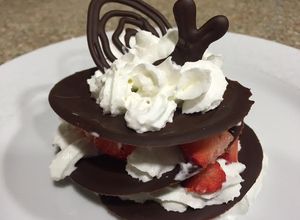 Una foto de Milhojas de chocolate con fresas y crema chantilly
