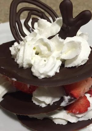 Una foto de Milhojas de chocolate con fresas y crema chantilly