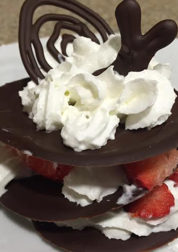 Una foto de Milhojas de chocolate con fresas y crema chantilly