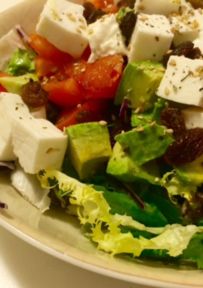 Una foto de Ensalada con tomate, queso fresco, aguacate y pasas