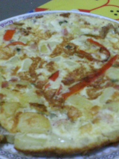 Una foto de Tortilla de papas y vegetales con tocineta