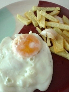 Una foto de Papas fritas con huevo frito
