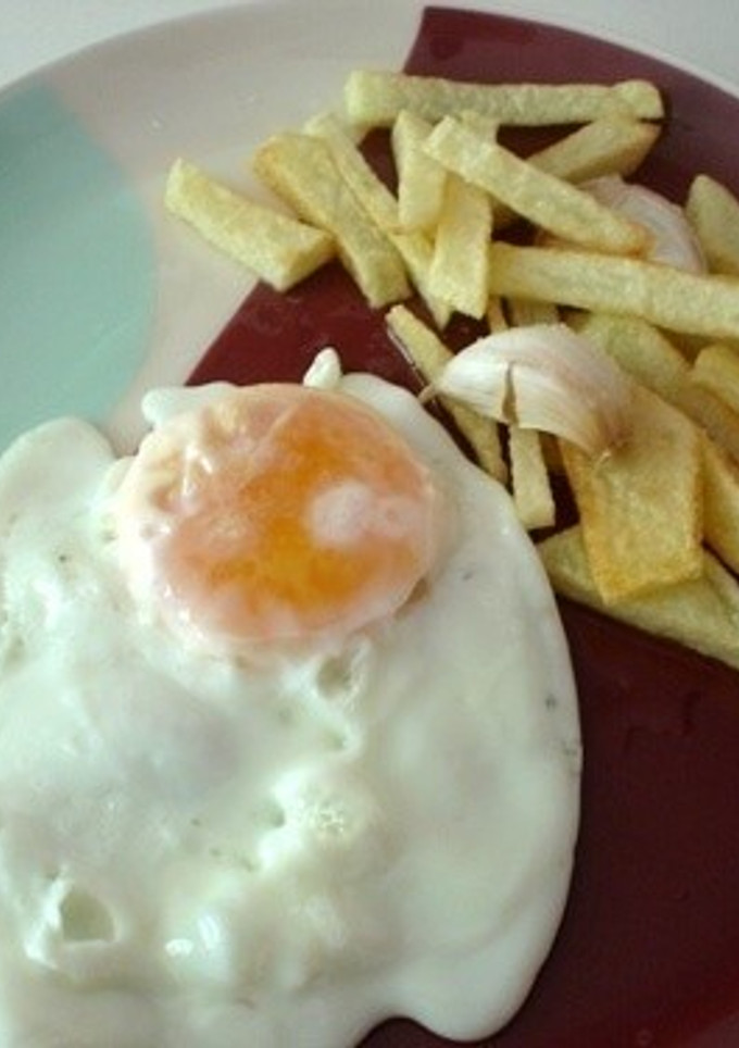 Una foto de Papas fritas con huevo frito
