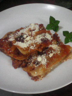 Una foto de Canelones con carne de res en salsa roja
