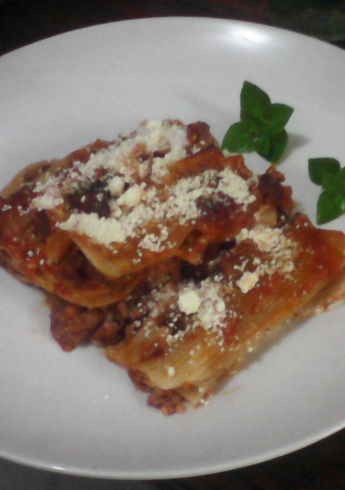 Una foto de Canelones con carne de res en salsa roja