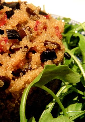 Una foto de Ensalada caliente de amaranto y senderuelas con jamón ibérico y ajo negro