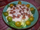 Ensalada de pollo y tomates amarillos sobre base de espinacas