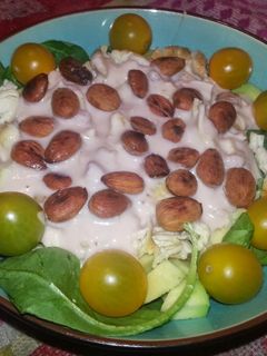 Una foto de Ensalada de pollo y tomates amarillos sobre base de espinacas