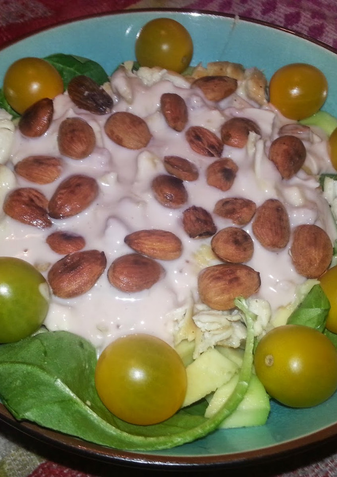 Una foto de Ensalada de pollo y tomates amarillos sobre base de espinacas