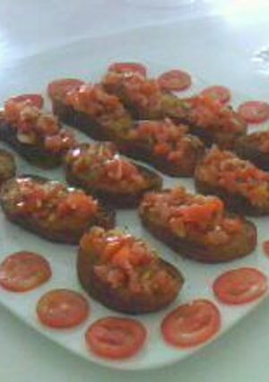 Una foto de Brucheta o pan tostado con tomate y perejil