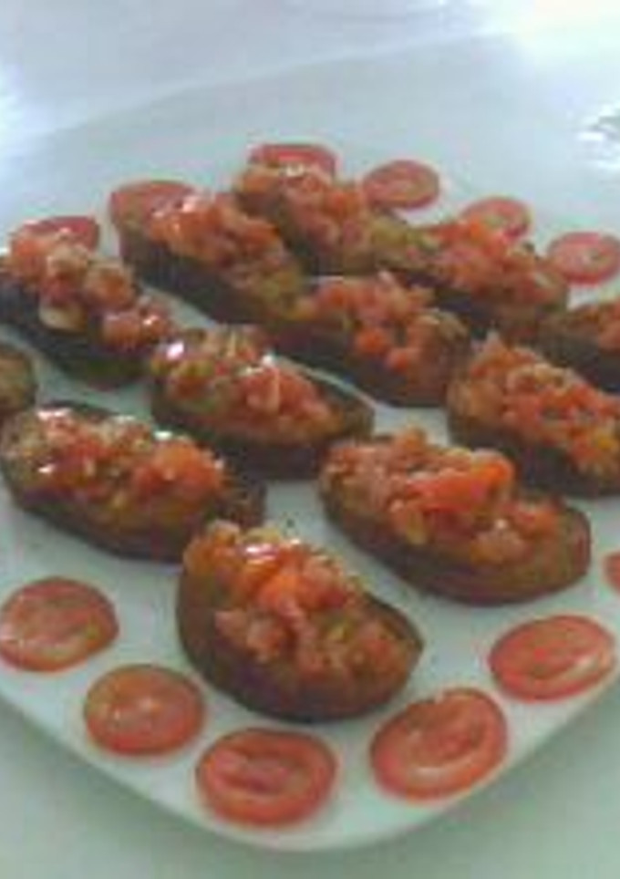 Una foto de Brucheta o pan tostado con tomate y perejil